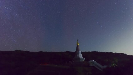 Wall Mural - time lapse 4k of the milky way galaxy moving over a sacred temple at doi inthanon national park, chi