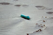 Plastikowe odpadki butelka pozostawiona na plaży. 	
