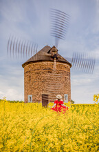 Girl In Front Of An Old Windmill In The Countryside