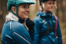 Mature Woman Preparing For A Mountain Bike Ride With Friends