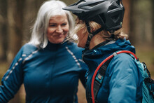 Smiling Daughter And Mother Going Mountain Biking In A Forest