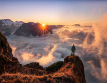 One Man Standing On Mountain Peak Over The Clouds