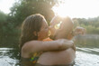 © STUDIO TAURUS/Stocksy - Happy young couple hugging in water