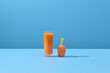 © Marc Tran/Stocksy - Carrot and glass of fresh juice on blue background
