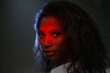 © Anna Berkut/Stocksy - portrait of beautiful black woman in studio, female face in red light