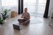© Milles Studio/Stocksy - Woman greeting online instructor with namaste gesture