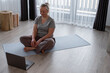 © Milles Studio/Stocksy - Positive female during online yoga lesson