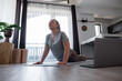 © Milles Studio/Stocksy - Woman stretching during online yoga lesson
