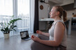 © Milles Studio/Stocksy - Woman relaxing during online meditation session