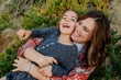 © Erin Brant/Stocksy - Laughing girl with happy mom on sand dune