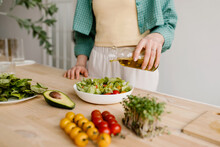 Woman Dressing Salad With Olive Oil