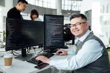 Portrait Of Chinese Male Engineer With Computer In Office