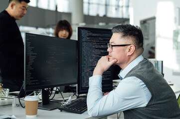 Portrait of Chinese male engineer with computer in office