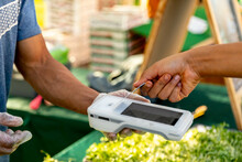 Woman Pays With Card At Outdoor Market With Wireless Payer