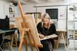 © Ezequiel Giménez/Stocksy - Woman with palette painting in craft studio