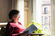 © Pedro Merino/Stocksy - Old woman reading a book at home