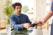 © Martí Sans/Stocksy - Businessman paying for order in restaurant