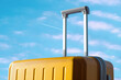 © Duet Postscriptum/Stocksy - Yellow travel suitcase against a blue sky with an airplane trail