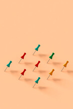 A Row Of Colorful Push Pins On Pink Background