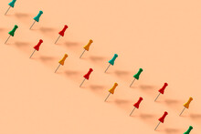 A Row Of Colorful Push Pins On Pink Background