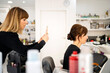 © Albert Martinez/Stocksy - Hairdresser taking picture of female client in salon