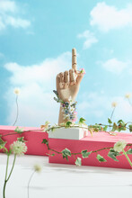 Wooden Hand With Flowers On Table On Cloudy Sky Background