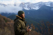 © Alba Vitta/Stocksy - Portrait of happy man drinking coffee cup in the mountain