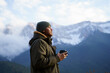 © Alba Vitta/Stocksy - Portrait of happy man drinking coffee cup in the mountain