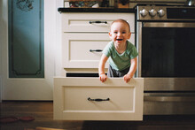 Cute Funny Baby Climbing Into Kitchen Drawers