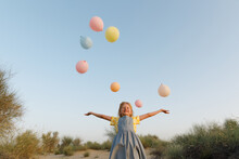 A Smiling Girl With Balloons Outdoors