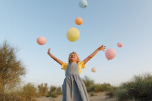 A Smiling Girl With Balloons Outdoors