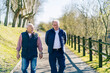 © Daniel Gonzalez/Stocksy - Senior men walking along promenade in city
