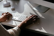 © David Prado/Stocksy - Crop woman working on computer in office