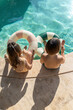 © Andriy Bezuglov/Stocksy - Children in swimsuits eating ice cream in pool outdoors
