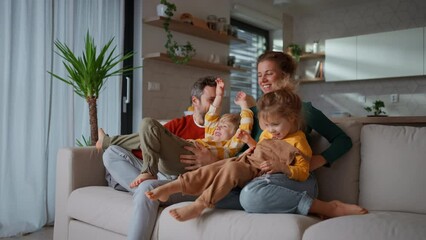 Wall Mural - Little children bonding with parents on sofa at home