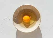 Cracked Egg In Ceramic Bowl