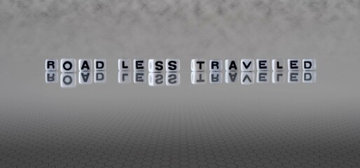 Wall Mural - road less traveled word or concept represented by black and white letter cubes on a grey horizon background stretching to infinity