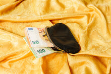 Purse With 50 And 100 Euro Notes On A Golden Background