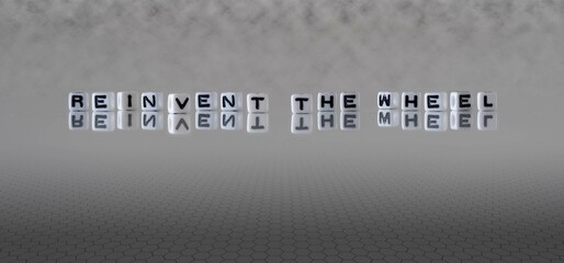 reinvent the wheel word or concept represented by black and white letter cubes on a grey horizon background stretching to infinity