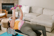 © ByLorena/Stocksy - Curvy woman lying down lifting pink light weights