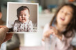 © Lauren Lee/Stocksy - Holding up a baby photograph