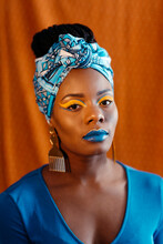 Woman With African Print Head Band And Creative Makeup Over Orange 