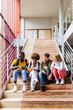 © VICTOR TORRES/Stocksy - Group of diverse friends sitting on stairs at university