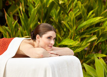Portrait Of Peaceful Woman Relaxing On Massage Table At Outdoor Spa