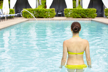 Woman Relaxing In Swimming Pool On Vacation At Luxury Resort And Spa