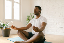 Millennial Male Meditating Indoors
