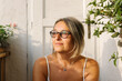 © STUDIO TAURUS/Stocksy - Portrait of a senior woman sitting outdoors in sunlight