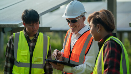 Concept: Renewable Energy. Team of engineers working to check the system through the phone. Photovoltaic for clean energy production. Innovate green energy for life on solar farms