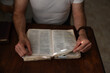 © Ameris Photography Inc./Stocksy - Man reading the bible at kitchen table.