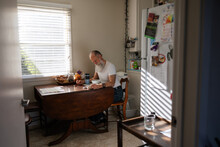 Man Reading The Bible At Kitchen Table.